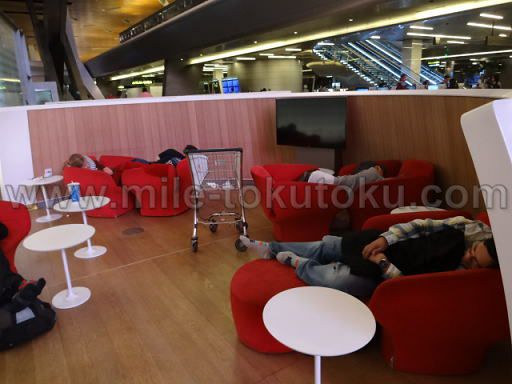 ドーハ空港 乗り継ぎ 2つの椅子をくっつけて寝る人